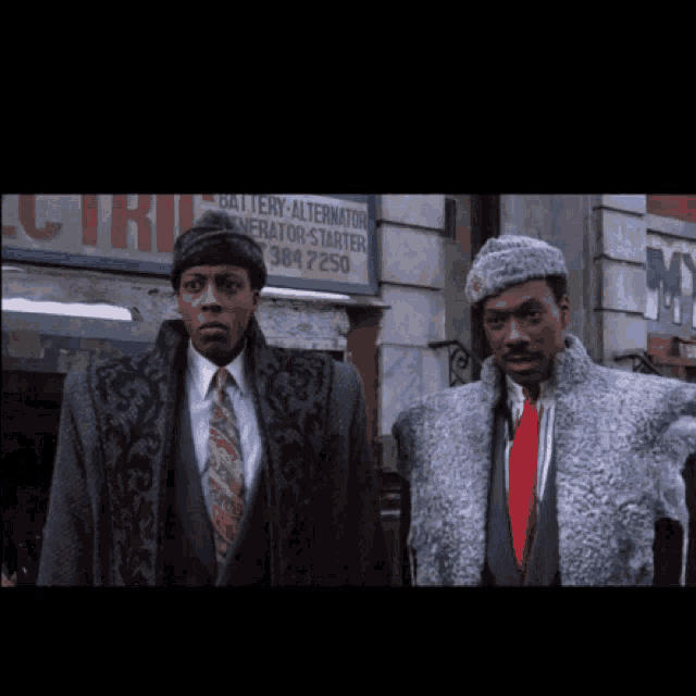 two men are standing in front of a building with a sign that says battery alternator generator starter