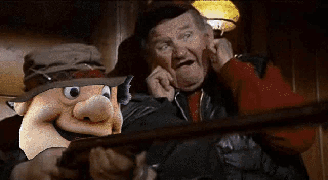 a cartoon character is holding a gun next to a man in a hat
