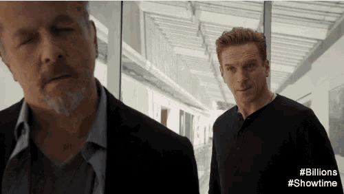 two men standing next to each other in a hallway with # billions showtime written on the bottom right