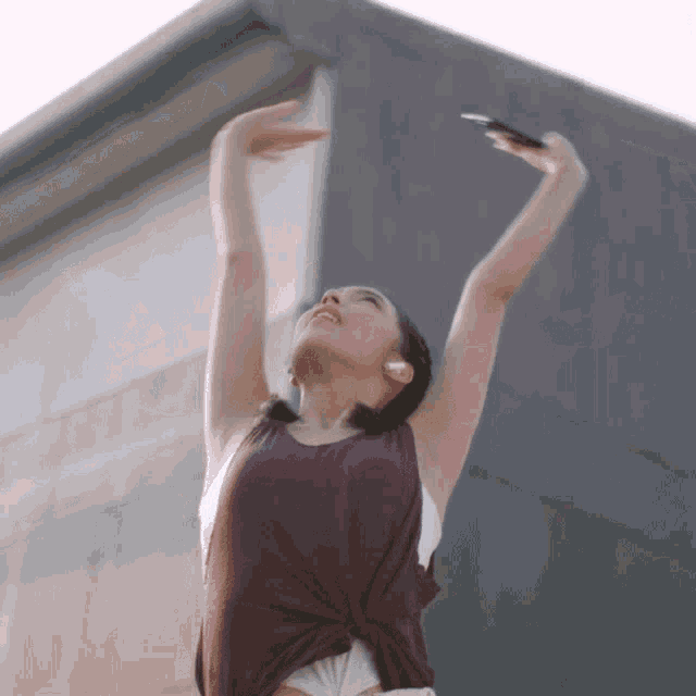 a woman with her arms in the air looking up