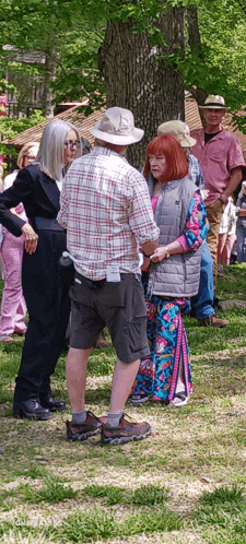 a man in a plaid shirt is talking to a woman in a colorful dress