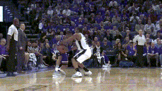 a basketball game is being played in front of a crowd that is purple