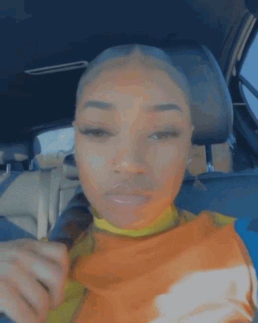 a woman is sitting in the back seat of a car looking at the camera .