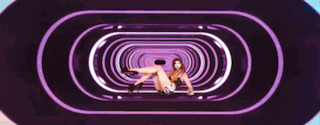 a woman is laying on her stomach in a purple tunnel .