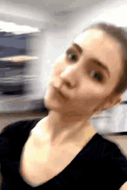 a woman in a black shirt looks at the camera