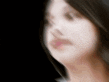 a blurry picture of a woman 's face with a black background