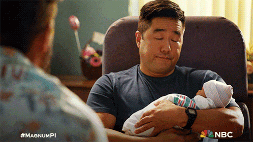 a man is holding a baby in his arms with the nbc logo on the bottom right