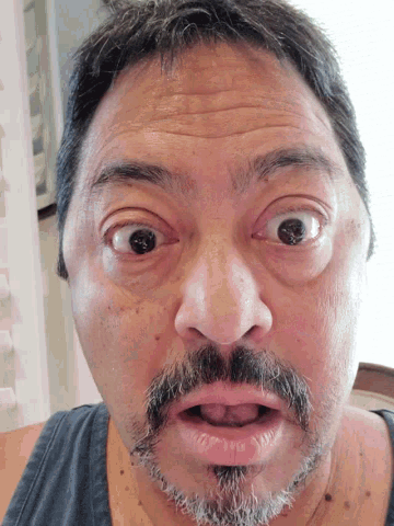 a man with a beard is making a funny face with his mouth open