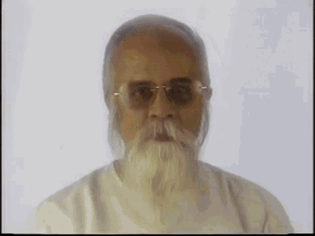 a man with a white beard and glasses is looking at the camera