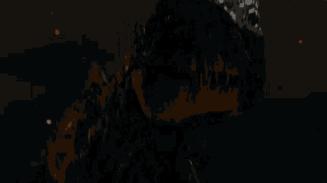 a close up of a black dinosaur 's face in the dark