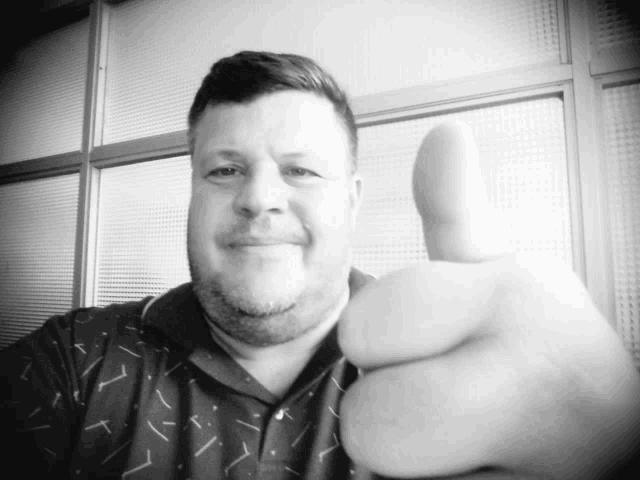 a man with a beard giving a thumbs up