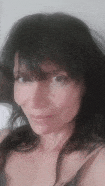 a close up of a woman 's face with a black bra on