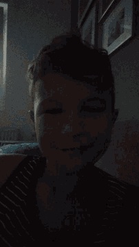 a person laying down with their eyes closed and a striped shirt on