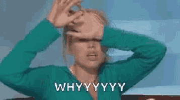 a woman in a green sweater is covering her face with her hands and says why .