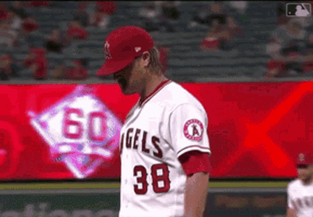 a baseball player with the number 38 on his jersey stands on the field