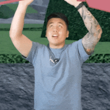 a man with a tattoo on his arm is wearing a blue t-shirt with the word love on it