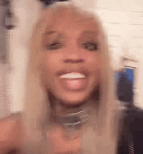 a blurry picture of a woman with blonde hair and a choker .