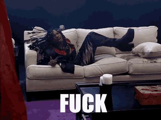 a person is laying on a couch with the word fuck written on it