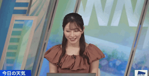 a woman sits in front of a sign that says win