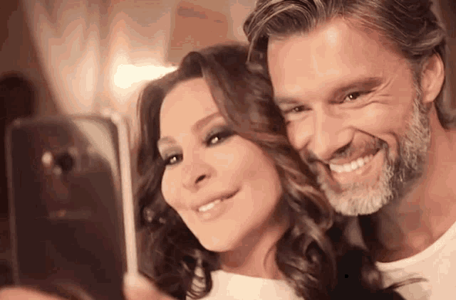 a man and a woman are posing for a selfie together