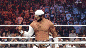 a man in a wrestling ring with a crowd behind him and the word back on the bottom right
