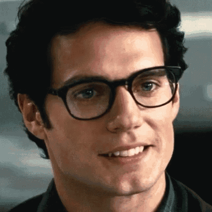 a man wearing glasses is smiling for the camera .