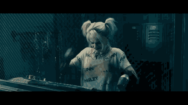 a woman in a harley quinn costume is standing in a dark room