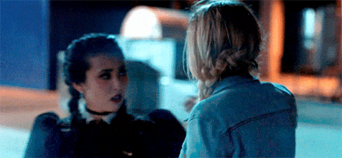 two women are standing next to each other in a dark room .
