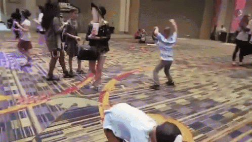 a group of people are dancing on the floor in a room .