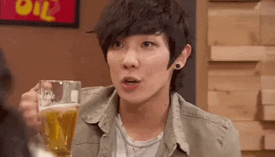 a young man is holding a glass of beer .