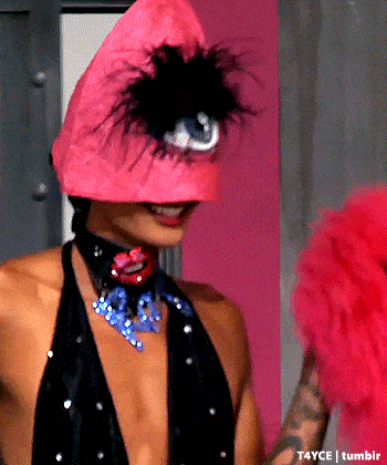 a woman wearing a pink hat with feathers on it
