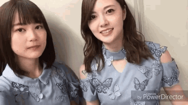 a couple of women are standing next to each other and smiling for the camera .