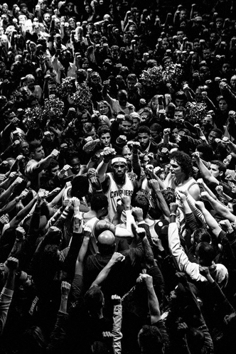 a man in a cavaliers jersey is surrounded by a crowd
