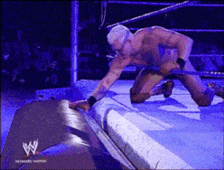 a man is kneeling down in a wrestling ring with a w logo on the bottom
