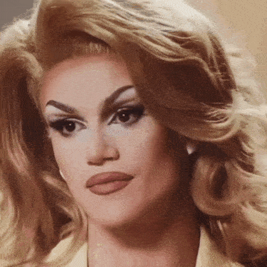 a close up of a drag queen 's face with blonde hair