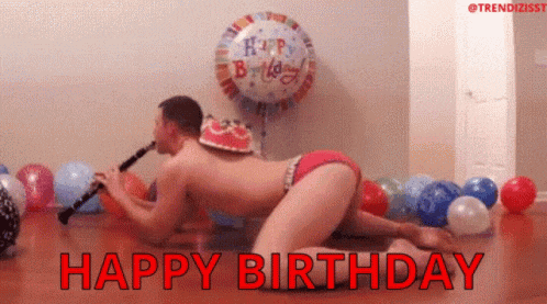 a man in underwear is playing a clarinet in front of a birthday cake and balloons .