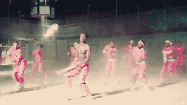 a group of people are dancing in front of a sign that says coca-cola