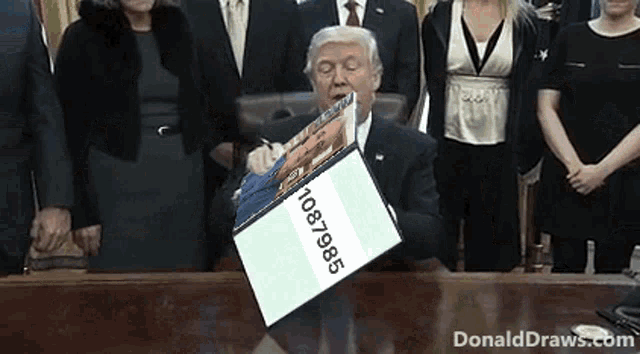 donald trump signing a bill with a box that says 10876985