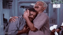 an older man is hugging a younger man in a movie .