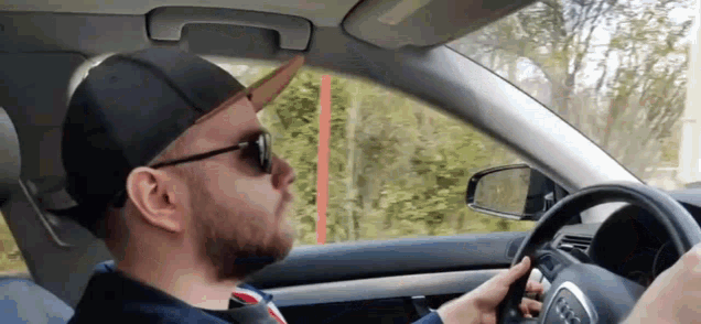 a man wearing sunglasses and a hat is driving a car