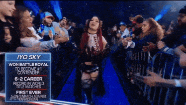 a female wrestler named jyo sky walks through a crowd of fans