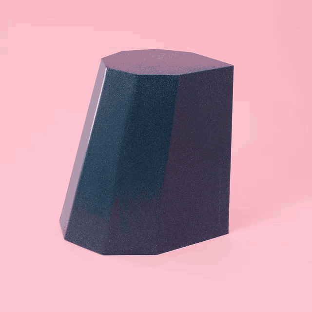 a black object is sitting on a pink background