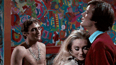 a man and two women are standing in front of a colorful wall ..