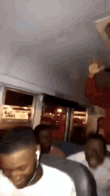 a group of people are sitting on a bus and one of them is wearing a red shirt