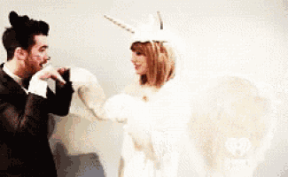 a man and a woman are standing next to each other wearing unicorn costumes
