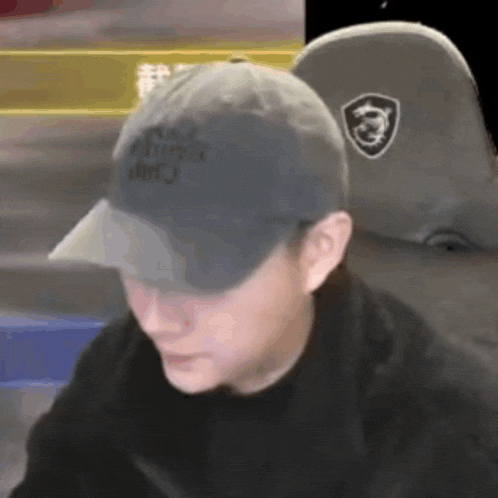 a man wearing a black hat with the word army on it looks at the camera