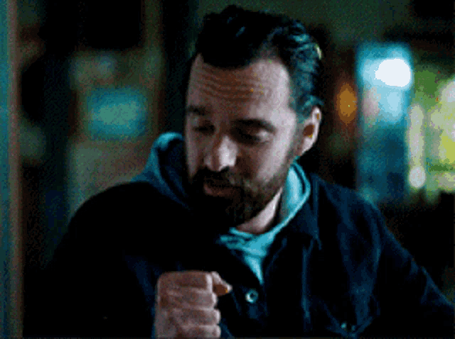 a man with a beard wearing a black jacket