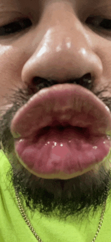 a close up of a person 's face with a beard and big lips