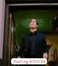 a man in a suit and bow tie is standing in a doorway and says `` that 's my bitch '' .