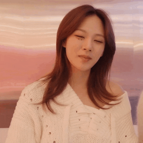a woman wearing a white sweater with holes in it